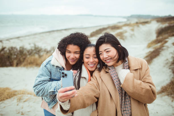 istock Three young women taking a selfie on a beach 1494695036