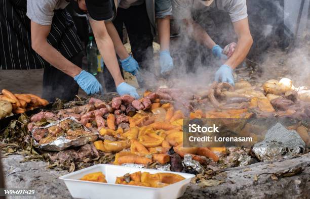 A Group Of Cooks Set Aside The Meat And Vegetables Prepared Underground As A Part Of The Curanto Ceremony Colonia Suiza Bariloche Argentina Stock Photo - Download Image Now