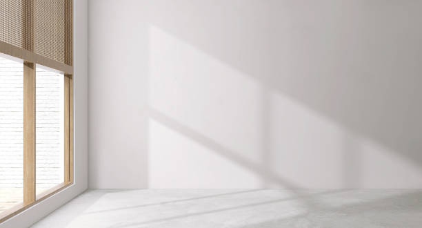 istock Empty room corner with large glass wooden frame window, blinds in sunlight, shadow on blank white wall, polished cement floor 1494699030