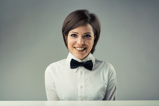 Enthusiastic vintage presenter from the '70s. White shirt, bowtie, boyish hair, intelligent, lively eyes. Half-bust portrait, retro color and mood