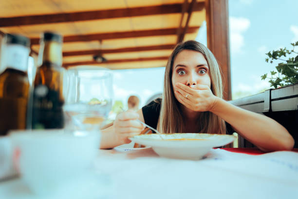 istock Woman Eating Soup in a Restaurant Feeling Sick 1494704245