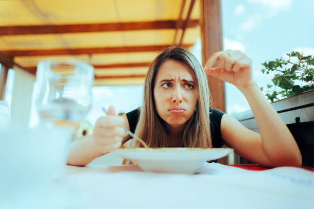 Une femme trouve des cheveux dégoûtants dans sa soupe dans un restaurant - Photo