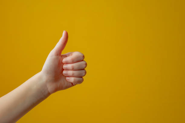 istock girl's hand making ok sign, on yellow background 1494710514