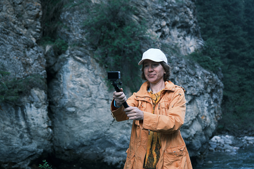 Female tourist is recording a video about her journey to mountains