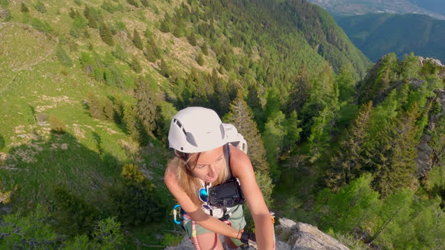 Woman rock climbing on Via Ferrata route