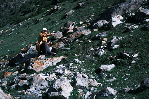 Female tourist is recording a video about her journey to mountains