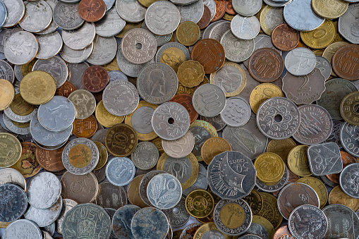 Top view of a collection of coins from various countries.