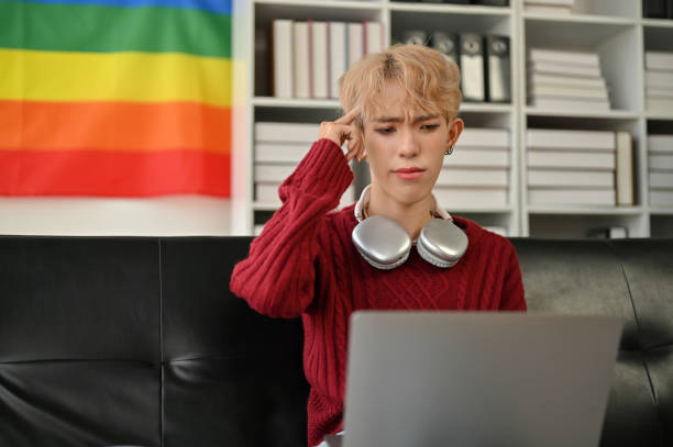 istock A confused young Asian gay man is using a laptop and trying to solve the problem 1494721836