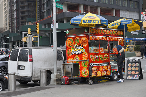 New York City - February 19, 2023: Street food cart in Manhattan street, in New York City, United States.