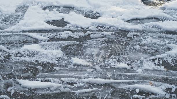 istock Sidewalk Covered in Snow with Imprint of Shoe Footprints 1494729152