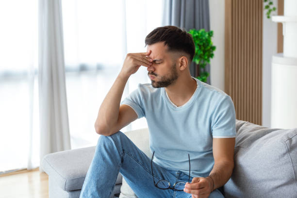 istock Upset man squeezing head with hands, writhing in pain, suffering from headache at home, copy space 1494730776