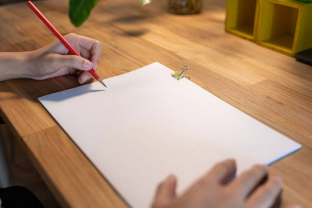 istock Cropped shot of female hand writing on blank notebook while working table. Woman's hand writing in notebook on white wooden table. 1494737778