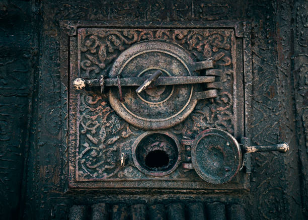 Close-up of a decorative cast-iron fireplace door in an old house.