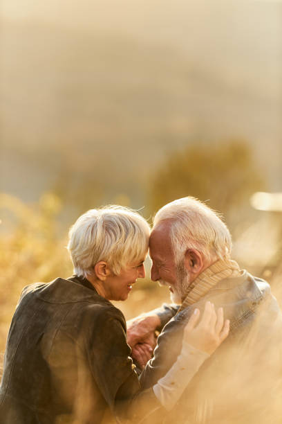 istock Affectionate mature couple talking in grass on a hill. 1494738811