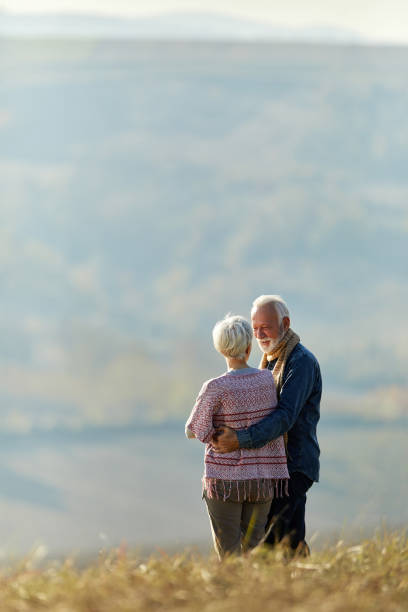 istock Happy senior couple talking while enjoying on a hill in autumn day. 1494738925