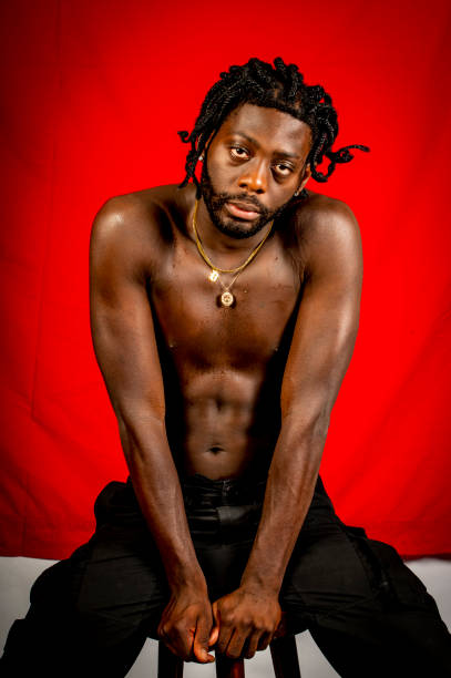 istock Young African Man with no shirt looks at camera. 1494740687