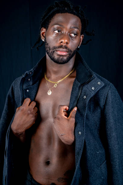 istock Young African man with torso showing wraps coat around him to keep warm 1494741144