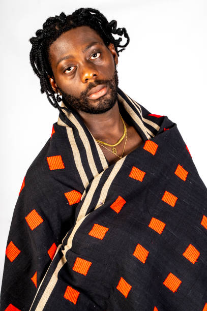 istock Young African man wrapped in distinctive black and red checked fabric moves. 1494741223