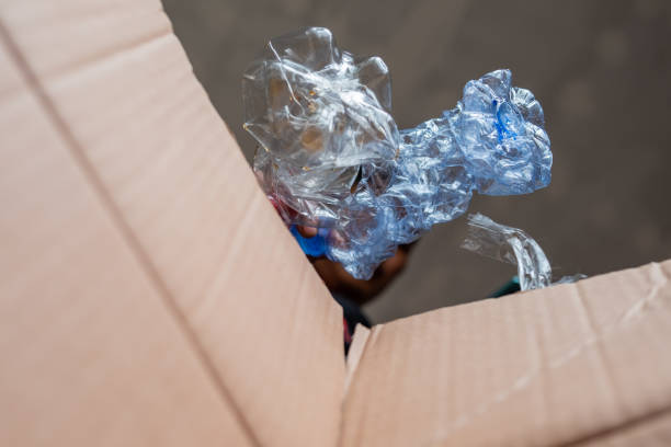 istock A man collects and puts recyclable plastic bottles in a cardboard box 1494742650