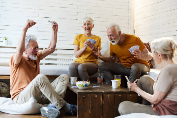 istock Happy senior friends enjoying while playing cards at home. 1494743015