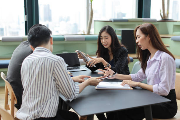istock Collaborative process of young asian business people team working together discussing, researching, brainstorming and planning work at business meeting in modern office building and city background 1494746465