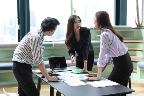 istock Collaborative process of young asian business people team working together discussing, researching, brainstorming and planning work at business meeting in modern office building and city background 1494746472
