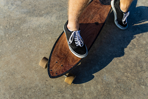 close up photo of man skateboarding near river at sunny summer day .