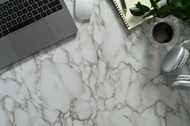 istock Laptop, notepad, headphone, notepad and coffee cup on marble table. Top view with copy space. 1494747210