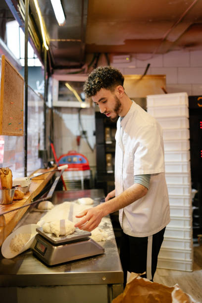 istock Pizza man weighing the dough on a scale 1494747584