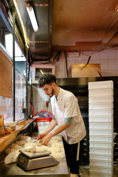 istock Pizza man weighing the dough on a scale 1494748597