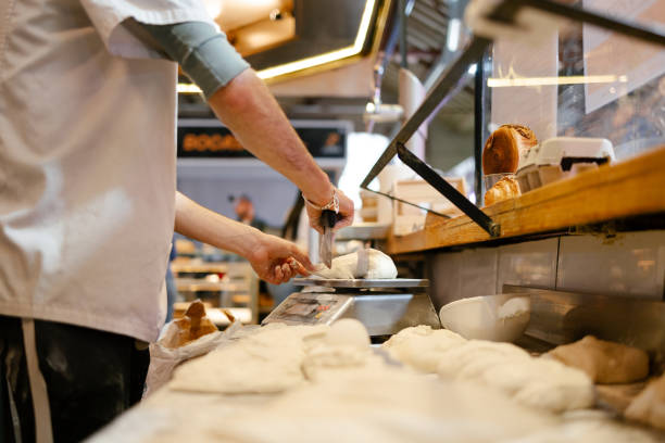 istock Close-up of unrecognizable man weighing dough on a scale 1494748645