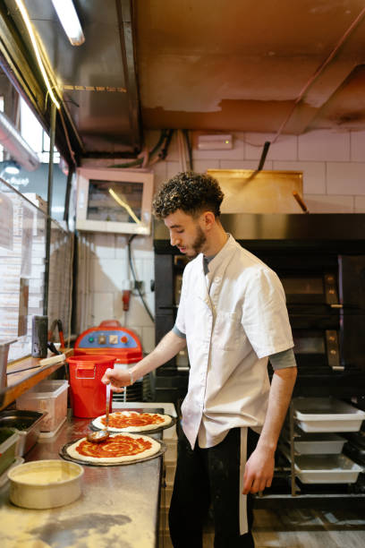 istock Pizza man making pizza in the kitchen of a pizzeria 1494748891