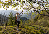Mature hiker explores mountain meadow in morning light