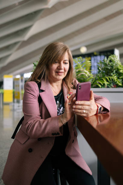 istock Senior woman using smartphone at airport 1494749610