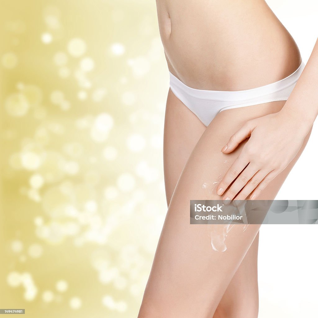 Donna applicando cosmetici Crema idratante corpo su - Foto stock royalty-free di Donne