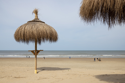 Reed umbrellas on a deserted sandy sea beach
