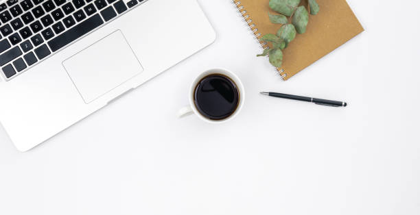 istock Laptop, notebook and a cup of black coffee on a white background, top view. 1494753132