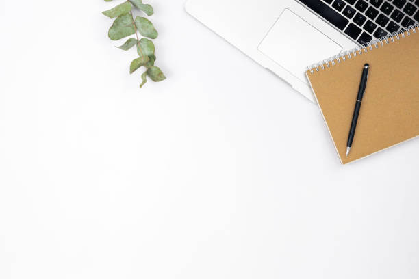 istock Minimalistic white background with laptop, notepad and pen, top view. 1494753137