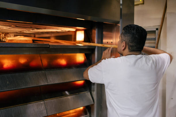 istock Latino baker cleaning oven 1494753227