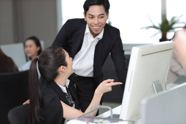 istock Attractive professional asian female employee worker working, using computer presentation and brainstorming ideas with coworker going over on new project together at office workplace 1494753506