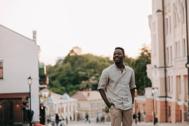 istock Young smiling african man is standing among street. 1494753525