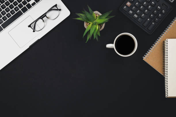 istock Flat lay black background with laptop, coffee cup and calculator, top view. 1494753656