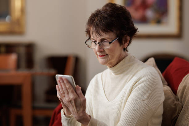 istock Senior woman at home using her phone 1494754813