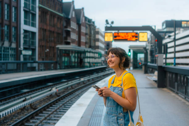 istock Woman waiting for the train on a subway station and using smartphone 1494754952
