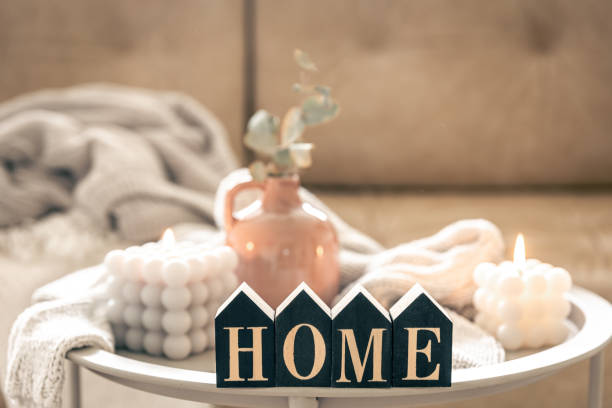 istock Cozy composition with decorative word home, candles and vase on blurred background. 1494755453