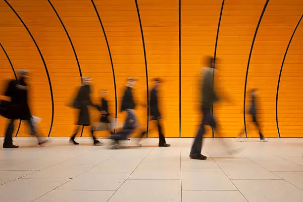 XXXL - motion blurred commuters in different sizes against modern orange subway walkway, orange wall in background - tiled floor in foreground - camera canon 5D mark II - unsharped RAW - adobe colorspace