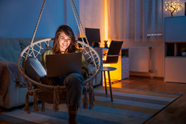 istock Woman using laptop computer while relaxing at home late at night 1494759131