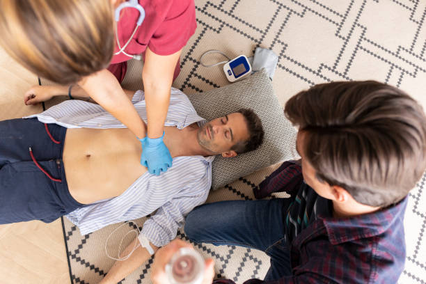 Emergency help for unconscious man, First aid preparation Emergency CPR for female doctor taking care of man with heart attack at home, A part of resuscitation process: healthcare and insurance concept. ayuda de emergencia para el hombre inconsciente, preparación de primeros auxilios rcp de emergencia para la doctora que atiende a un hombre con ataque cardíaco en el hogar, una parte del proceso de reanimación: concepto de atención médica y seguro.