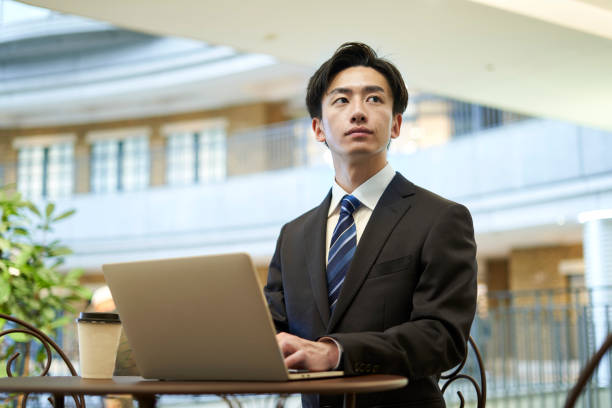 homme d’affaires japonais travaillant dans un café - laptop japanese ethnicity businessman desk photos et images de collection