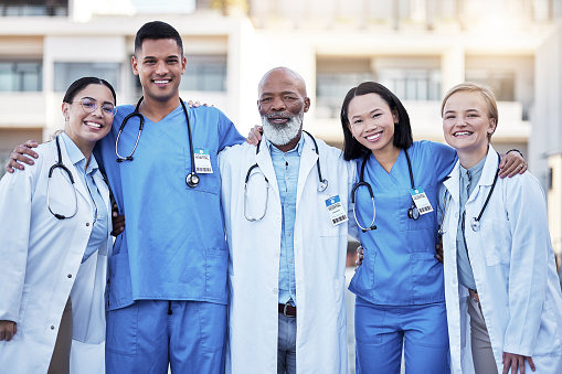 Teamwork, healthcare and doctors with nurses in medicine standing outdoor at a hospital as a team you can trust. Medical, collaboration or laughing with a man and woman medicine professional group
